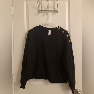 Women’s size medium H&M black sweater with gold button shoulder trim.